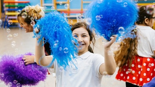 A girl dancing with blue pompoms 