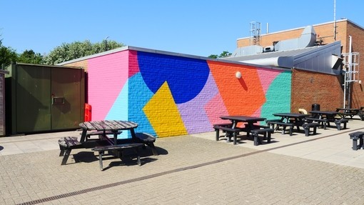 A brick wall painted in bright colours