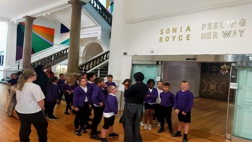 Children wearing purple jumpers in Leeds Art Gallery.